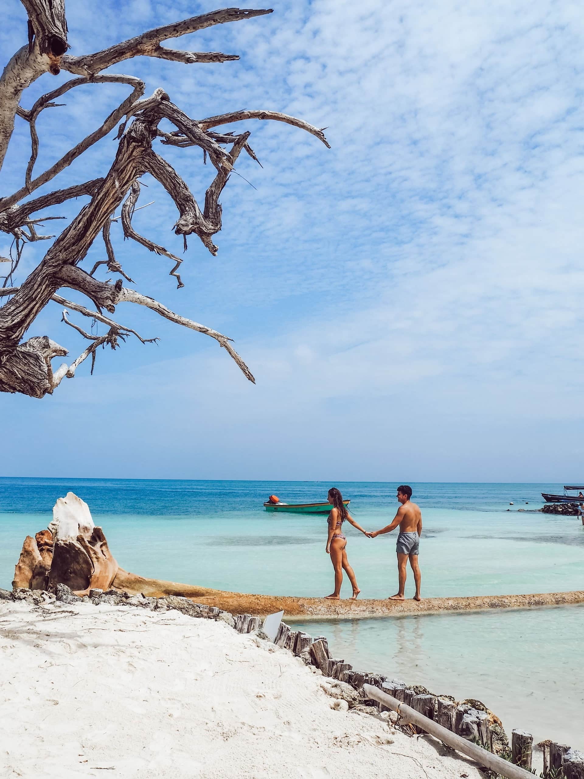Couple marchant main dans la main sur une plage en Colombie Couple marchant main dans la main sur une plage en Colombie